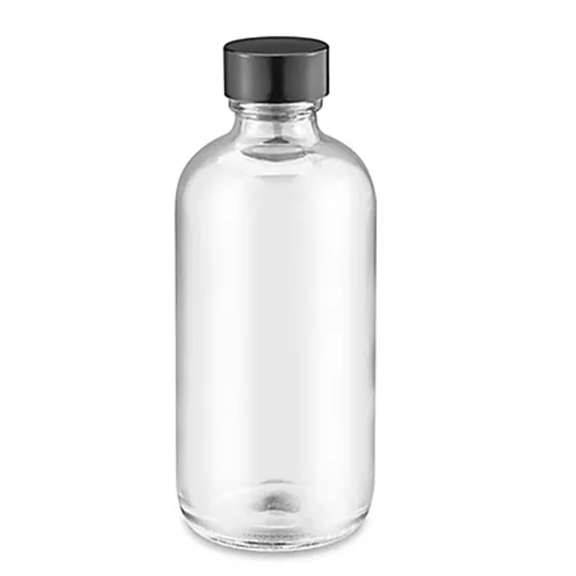 Unfilled clear glass bottle with black screw on top on a white background.