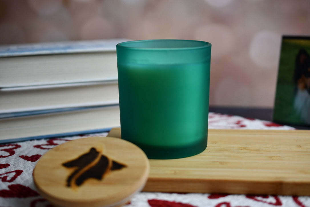 Frosted teal glass candle vessel with wooden lid hand branded with the Collie Creek Candles logo.