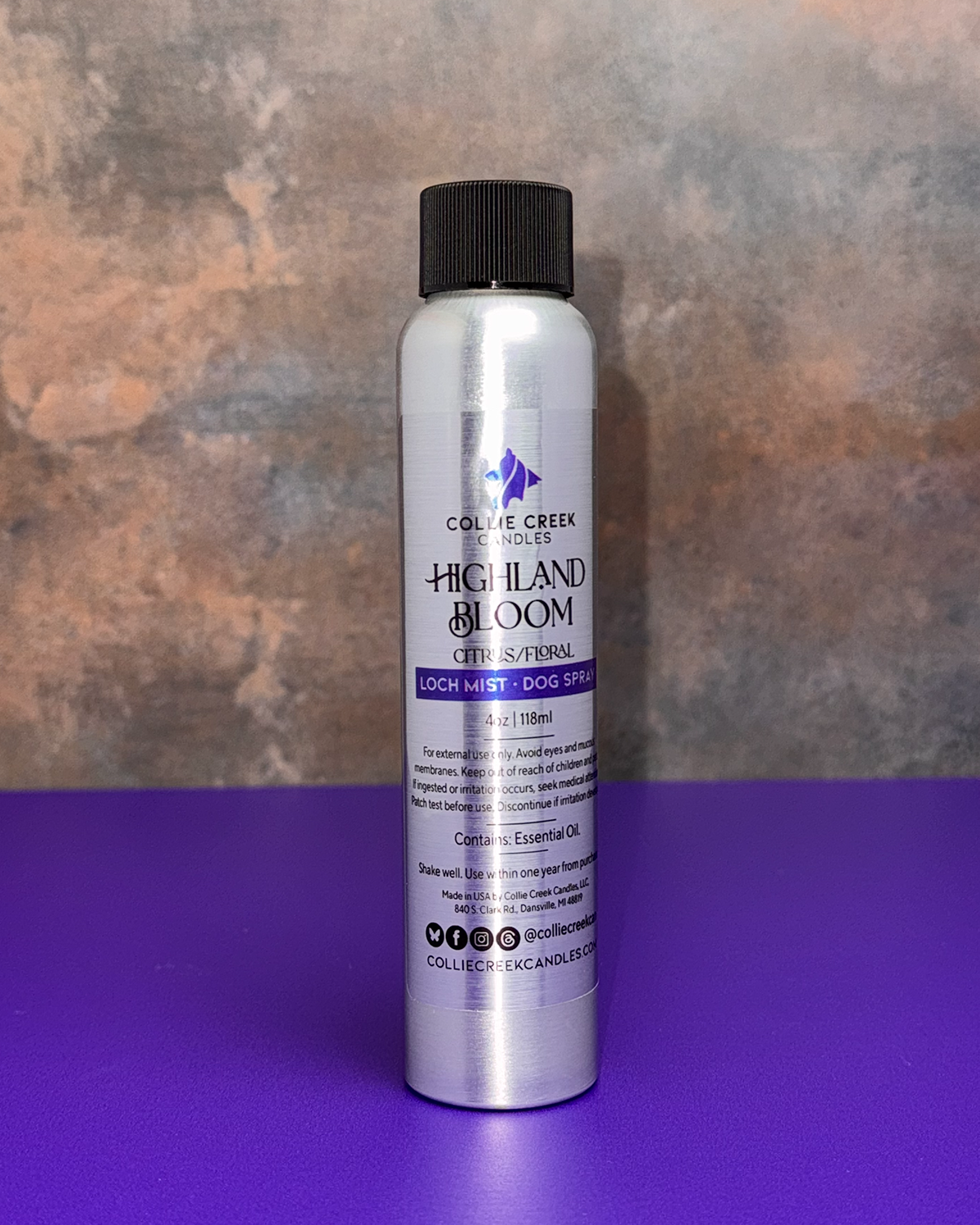 Highland Bloom Dog Spray. A sliver 4 ounce bottle with a black shipping top. A silver label with black and purple writing.