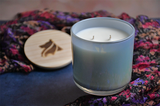 Gray iridescent candle vessel filled with a creamy, naturally colored para-soy wax with 2 wicks. The lid to the vessel is in the distance and has a hand-branded Collie Creek logo branded on it. The Beyond the Rainbow Brdige candle is for any type of pet loss and can be sent as a direct gift.