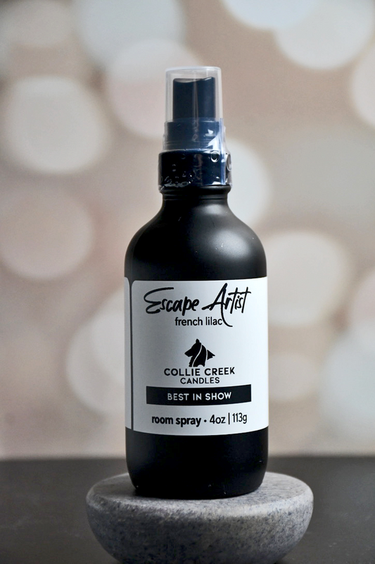 4 oz matte black bottle with white label with black lettering. This room spray comes in many scent profiles. This scent profile called Escape Artist and is a french lilac, from Collie Creek Candles.