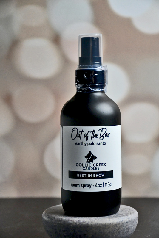 4 oz matte black bottle with white label with black lettering. This room spray comes in many scent profiles. This scent profile is called Out of the Box and is earthy palo santo, from Collie Creek Candles.