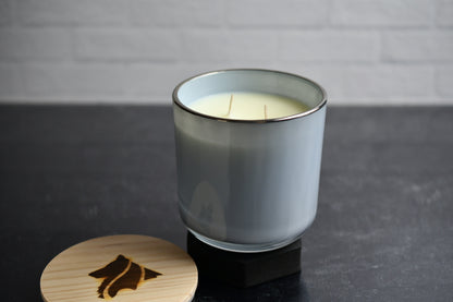 13 ounce candle in silver rimmed glass vessel on a kitchen counter background.