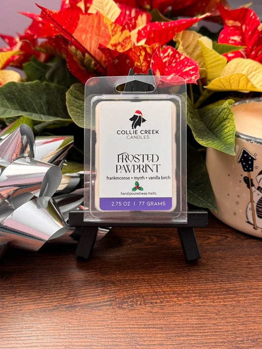 Collie Creek Candles Frosted Pawprint wax melt packaging with poinsettias in the background