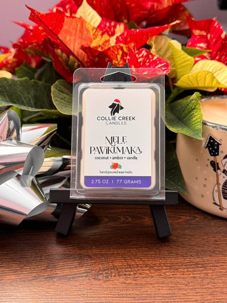 Collie Creek Candles wax melt Mele Pawikimaka packaging with flowers and  a silver bow in the background