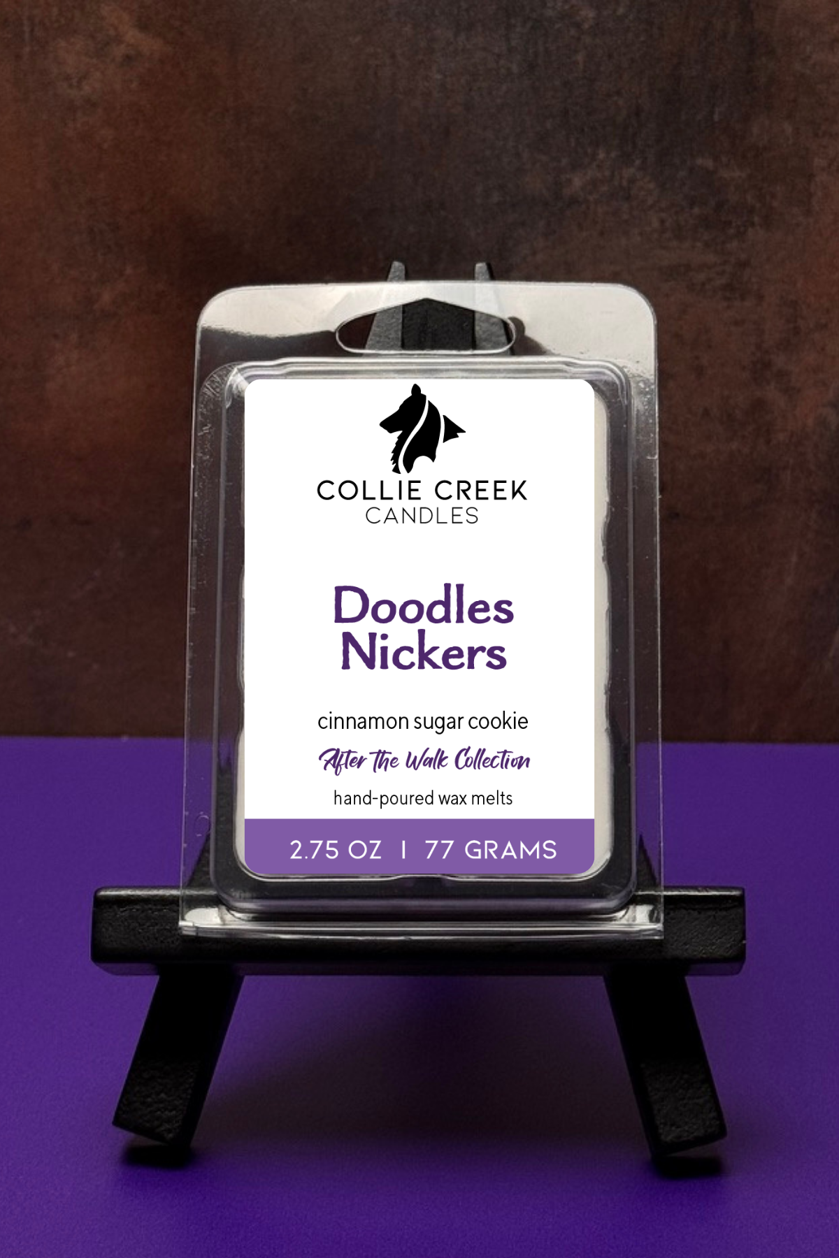 Single wax melt in a clear clam shell on a colored background, Doodles Nickers in purple on a white label.