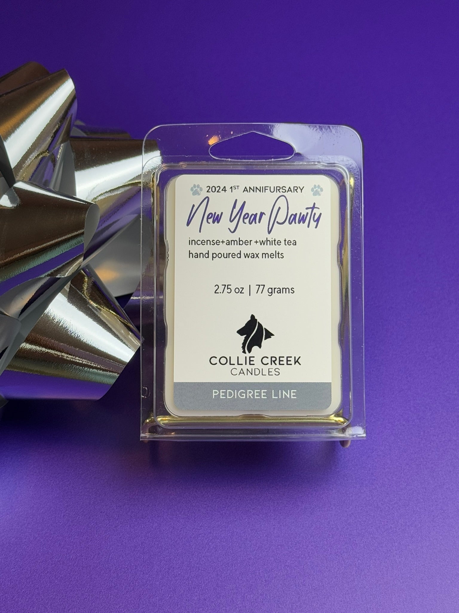 Wax melt called New Year Pawty from Collie Creek Candles on a field of purple