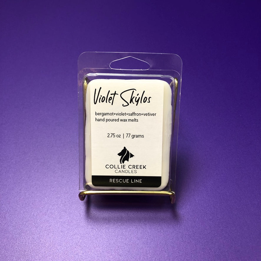 Viloet Skylos 6 cavity wax melts in clear recyclable plastic container on purple background.