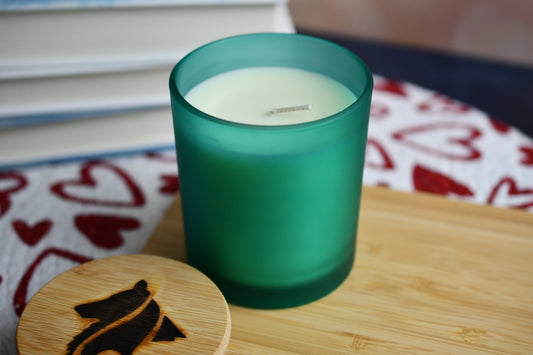 Frosted, teal candle jar holds creamy, natural colored single-wick parasoy candle. The "Gotcha Day" candle smells like birthday cake and makes a great gift.