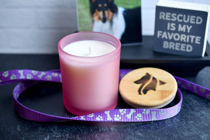 Single cotton wick 8oz candles in frosted pink glass vessel. A purple and silver dog leash wraps around the products which feature a hand-branded wooden lid.