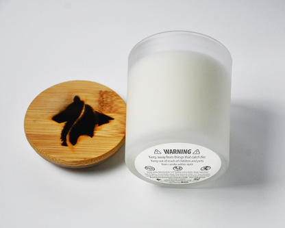 Side view of a frosted white candle product image featuring a single wick and hand branded Collie Creek Candles logo candle lid on white background.