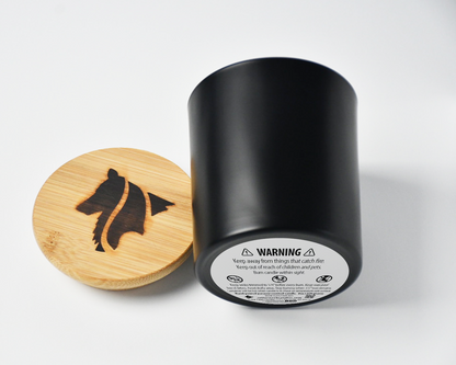 Side view of a black matte candle product image featuring a single wick and hand branded Collie Creek Candles logo candle lid on white background.