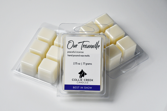 Our Trouvaille wax melt in clear plastic clamshell. Nested above two other clear clamshells with natural color wax melts, turned upside down to reveal the 6 cubes of each clamshell.